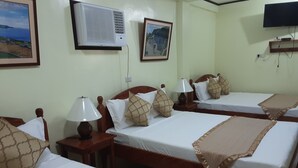 A hotel room with two beds, a TV, an air conditioner, and framed pictures on the wall. - Batanes Casa Feliciano (Basco)