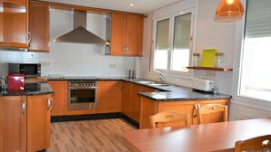 Una cocina moderna con armarios de madera, estufa de acero inoxidable, microondas y un lavamanos.