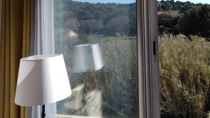 Une pièce avec vue sur un paysage boisé, visible par une fenêtre.