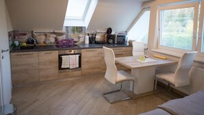 Eine kompakte Küche mit Essbereich, einem eingebauten Backofen und einem Fenster, das für natürliches Licht sorgt.