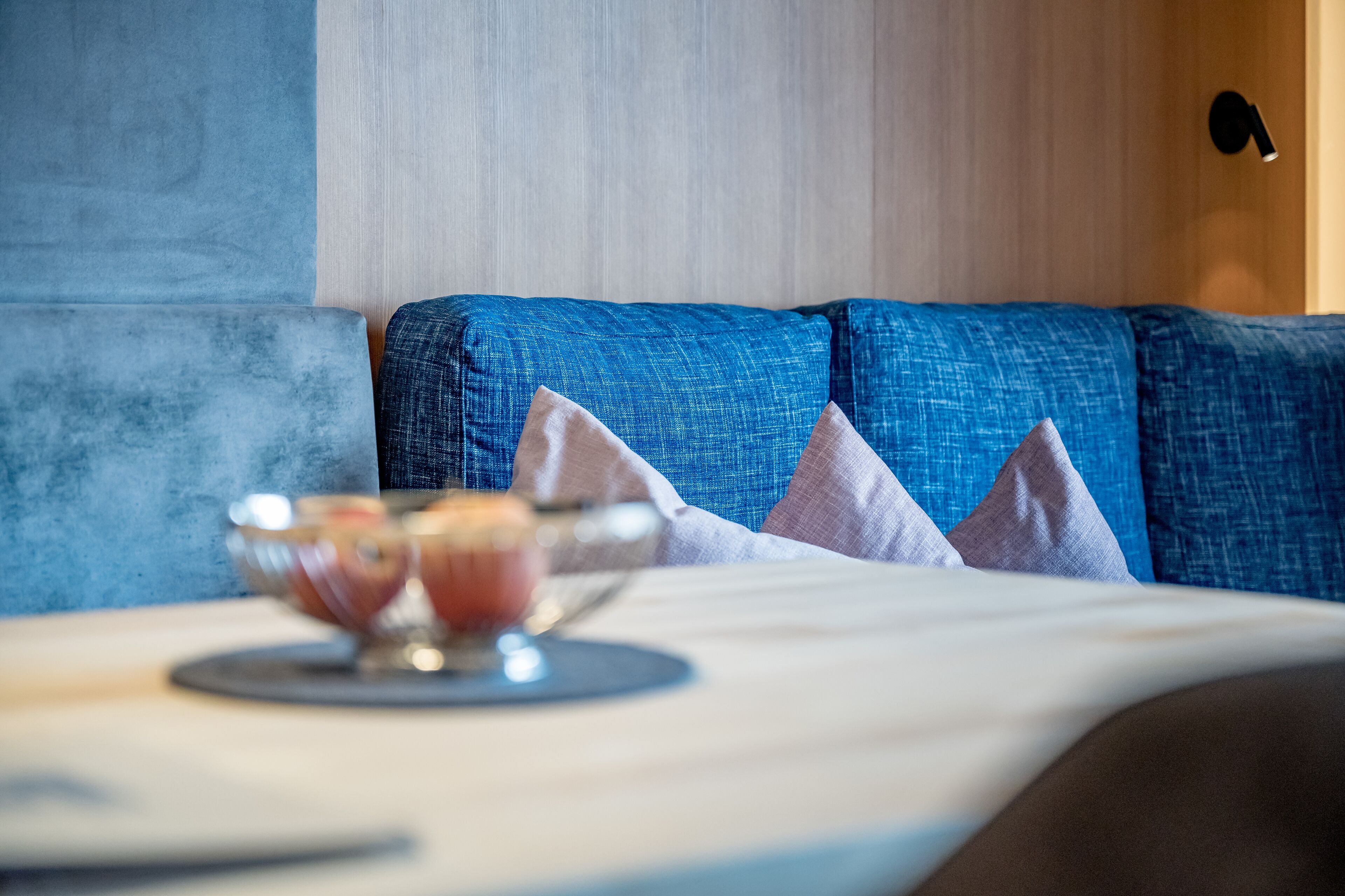 A dining area with a table set for two, featuring a glass bowl and a plate.
