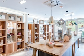 A modern interior with wooden shelves and a central table displaying various decorative items. - Hotel Andy (Jerzens)
