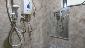 A bathroom with a pedestal sink, a handheld showerhead, and a wall-mounted mirror. - Rjat Guesthouse (Calamba)