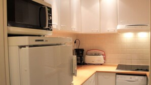 Una cocina compacta equipada con microondas, refrigerador, tostadora y lavavajillas.