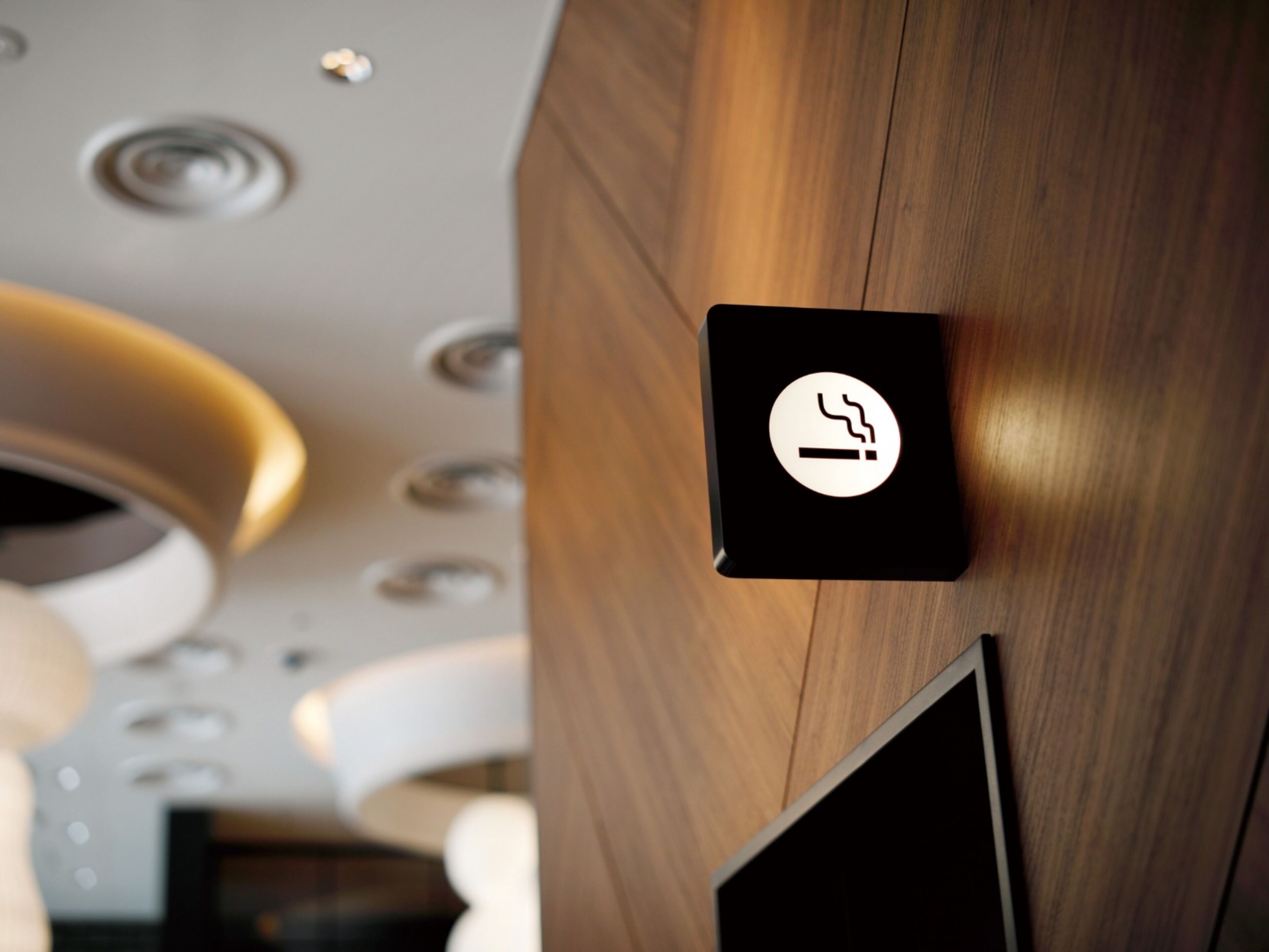 A modern interior with a wooden wall and a smoke symbol indicating a no-smoking area.