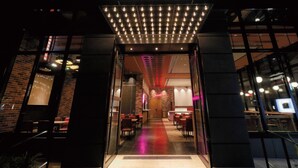 The entrance to a restaurant with a modern design, featuring a neon sign and a well-lit interior. - DEL style Osaka Shin Umeda by Daiwa Roynet Hotel (Osaka)