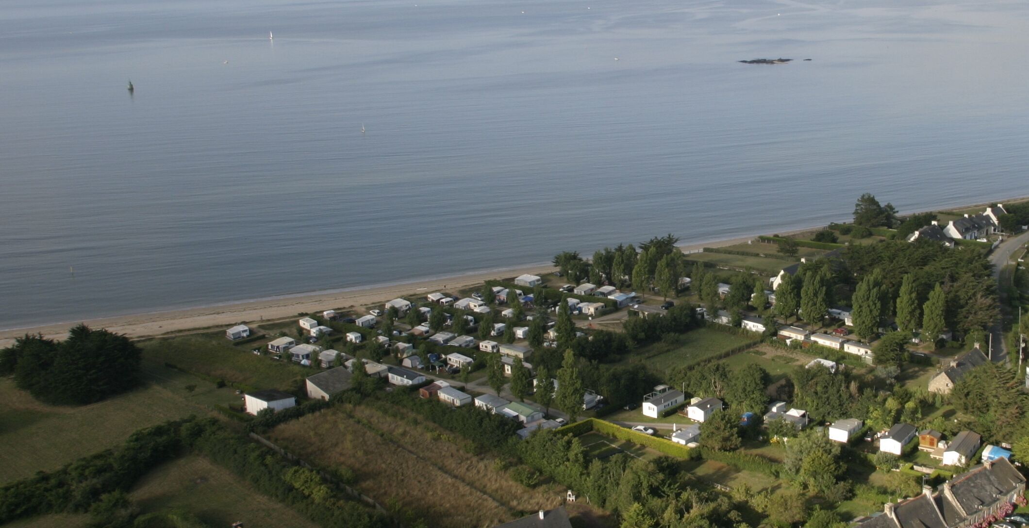 Vista aérea de una zona residencial costera con casas y una playa.