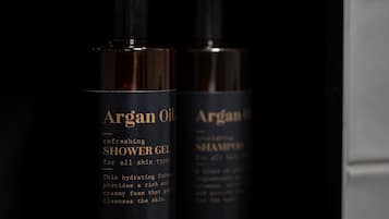 Two bottles of Argan Oil products in a black shelf.