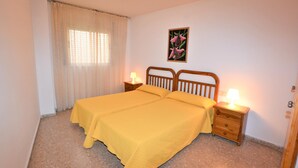 Una camera da letto con due letti, un comodino, una lampada, un quadro e una porta.