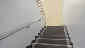 A staircase with a metal handrail and alternating dark and light steps. - OYO 549 Sajj Bldg (Baguio)