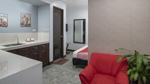 A modern kitchen with a sink, cabinets, and a door leading to another room. - OYO 549 Sajj Bldg (Baguio)