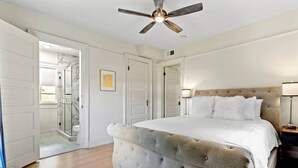 A bedroom with a large bed, a ceiling fan, and a walk-in closet. - Luxe 3BR on Magazine St with private pool & patio. Sleeps 6, walk to cafés, near FQ & Superdome. (New Orleans)