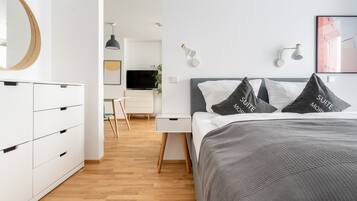 Ein modernes Hotelzimmer mit Bett, Nachttischen, Schreibtisch und Kleiderschrank.