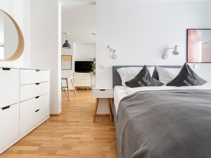 A modern hotel room with a bed, bedside tables, a desk, and a wardrobe. - Limehome Leipzig Jahnallee (Leipzig)