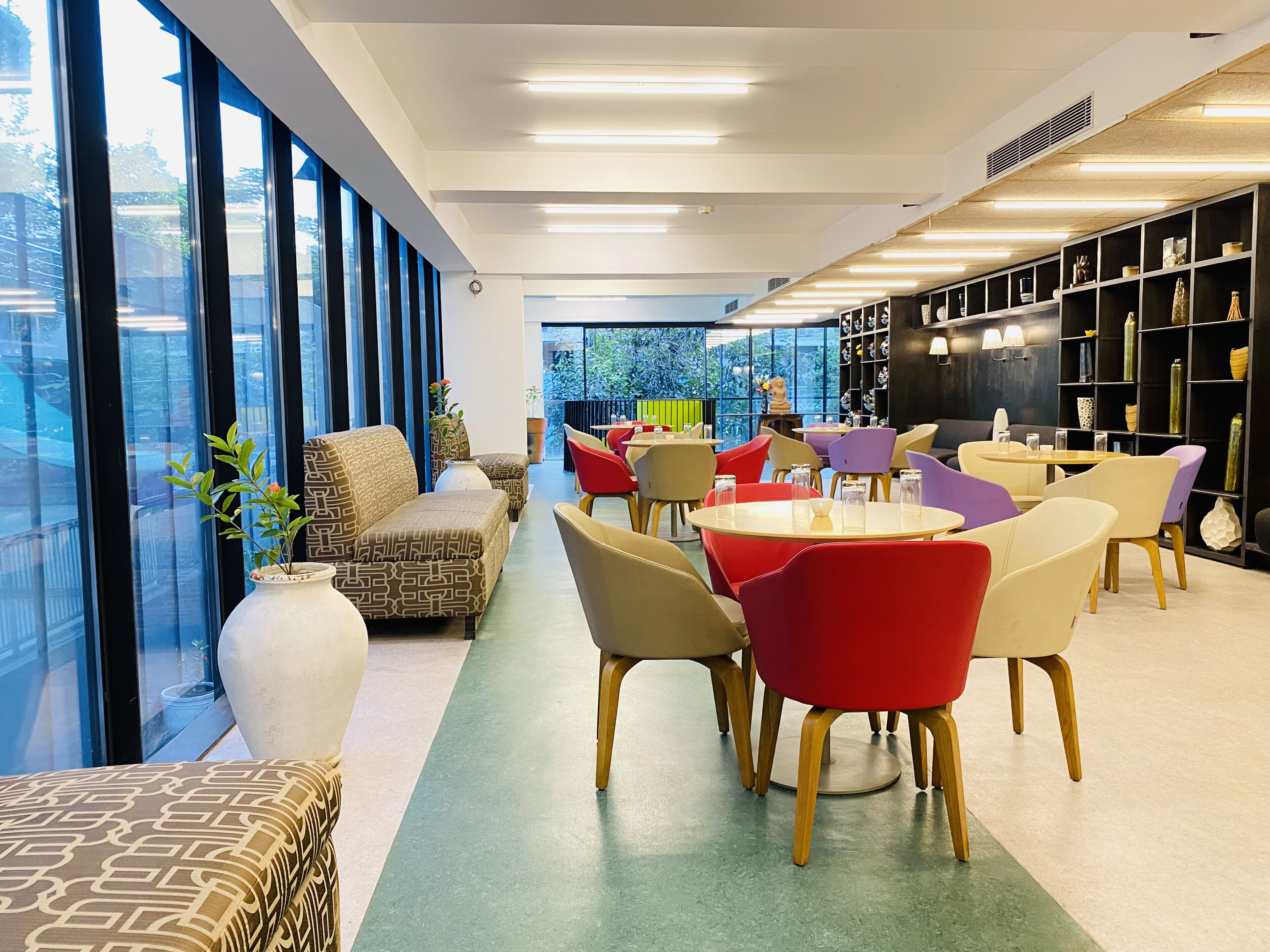 A modern interior with a sofa, chairs, and a bookshelf.