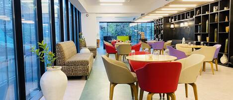 A modern interior with a sofa, chairs, and a bookshelf.