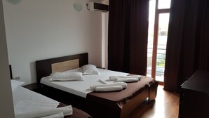 A hotel room with a bed, a desk, a chair, an air conditioning unit, and a view of the outside. - Vila 21A (Costinesti)