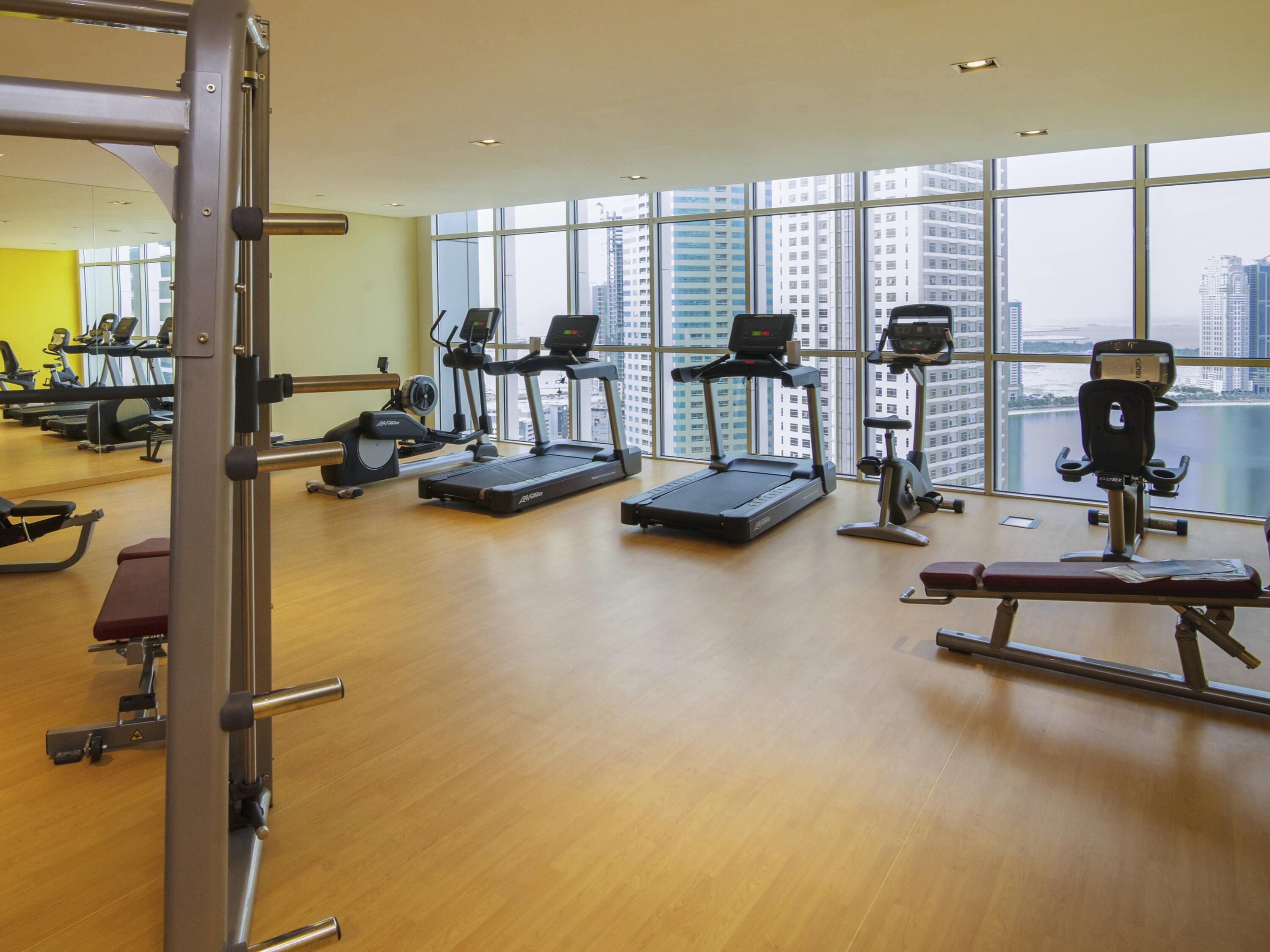 A gym with treadmills, elliptical machines, and weight machines.