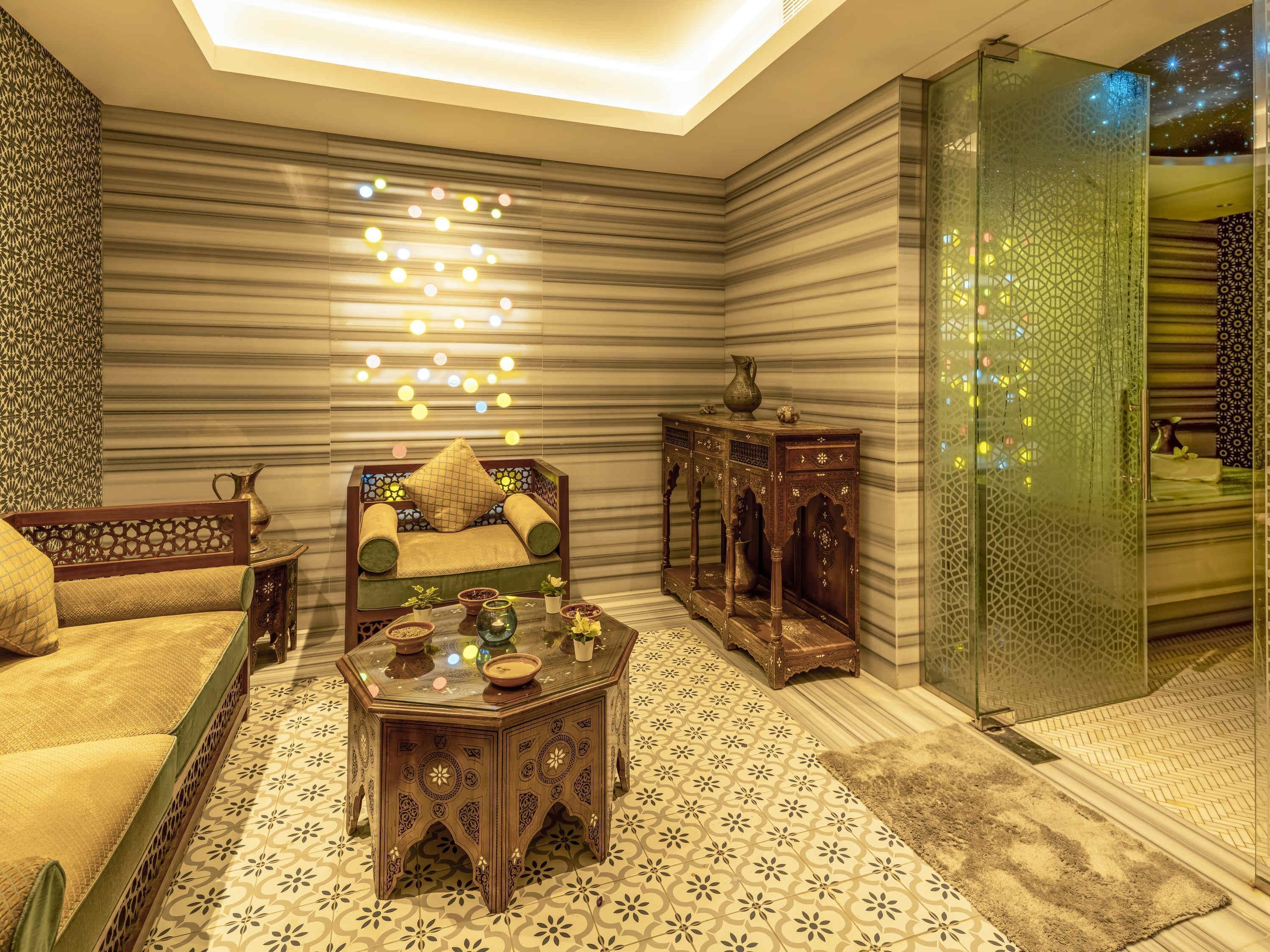 A room with a sofa, a coffee table, and a patterned floor.