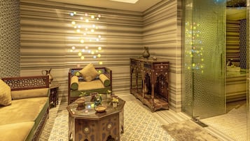 A room with a sofa, a coffee table, and a patterned floor.