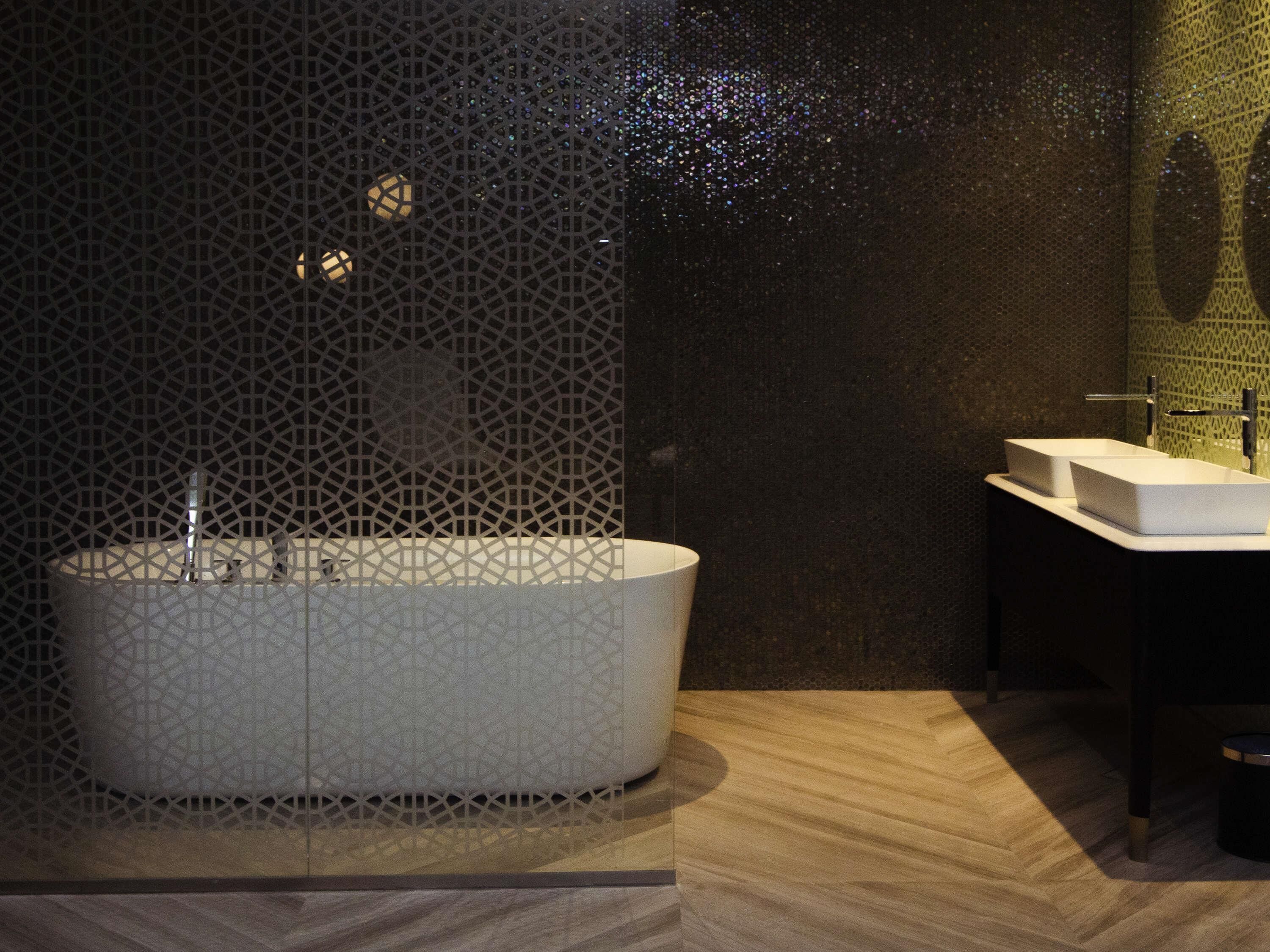 A modern bathroom with a freestanding bathtub, a rectangular sink, and a patterned wall.
