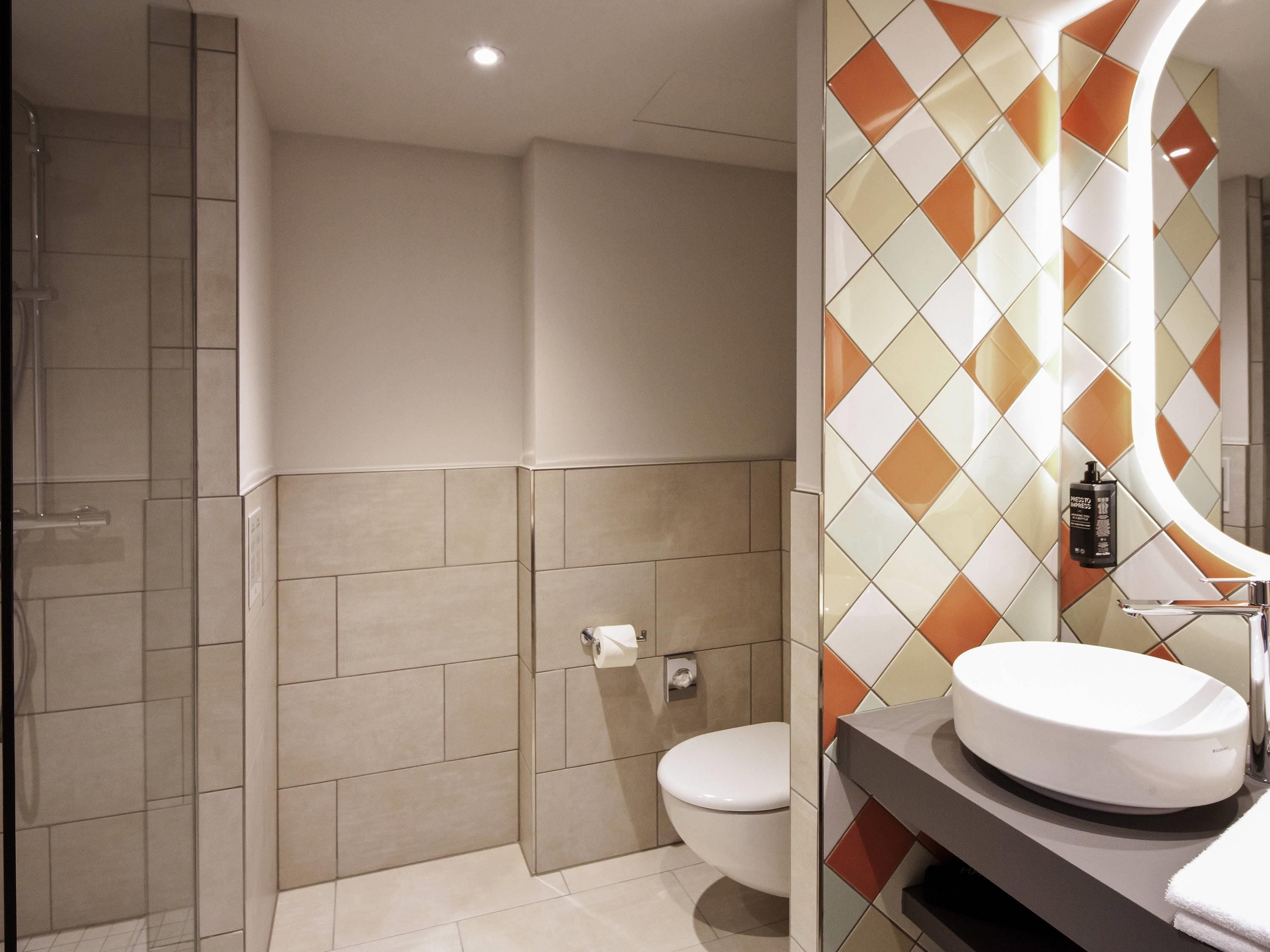 A bathroom with a shower, toilet, and sink.