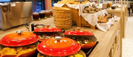 A buffet with various food items, including eggs, pastries, and a wicker basket.