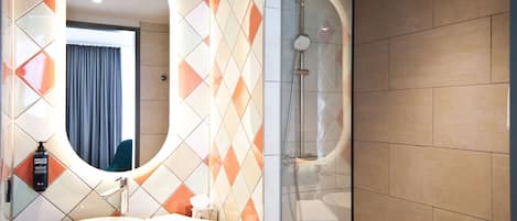 A modern bathroom with a round sink, a mirror, and a shower.