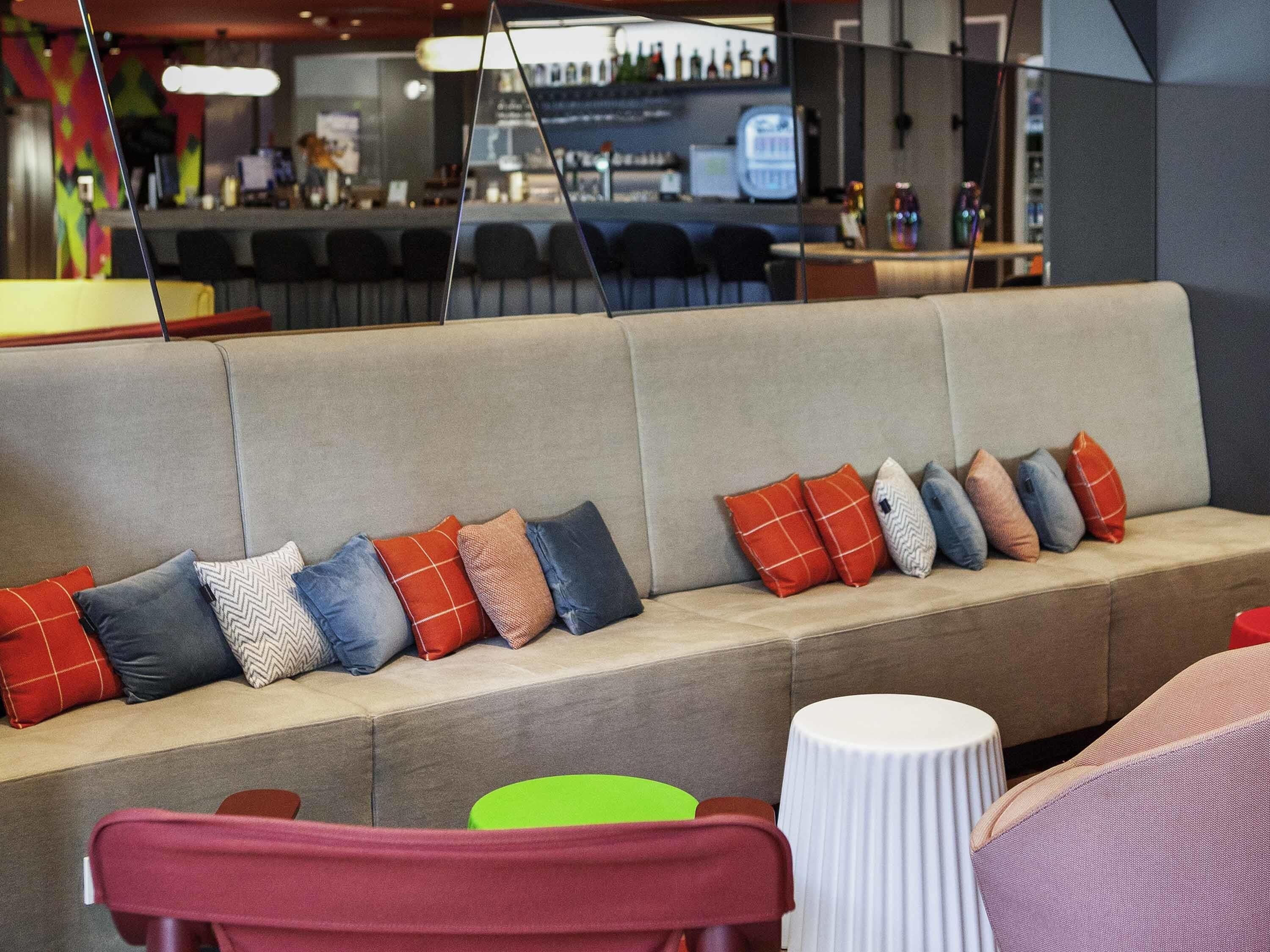 A modern bar area with a sofa and chairs, a bar counter, and a seating area with a round table.