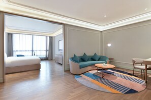 A modern hotel room with a sofa, a small round table, and a bed. - Mercure Guangzhou Nansha (Guangzhou)