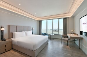 A modern hotel room with a large bed, a desk, and a view of the city. - Mercure Guangzhou Nansha (Guangzhou)