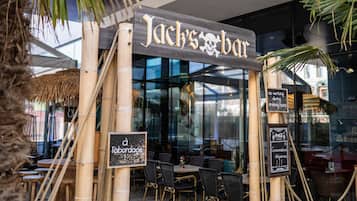 Een bar genaamd 'Jack's Bar' met terras en een glazen overkapping.