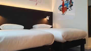 Habitación de hotel con dos camas, ropa de cama blanca, cabecera oscura y una lámpara fijada a la pared.