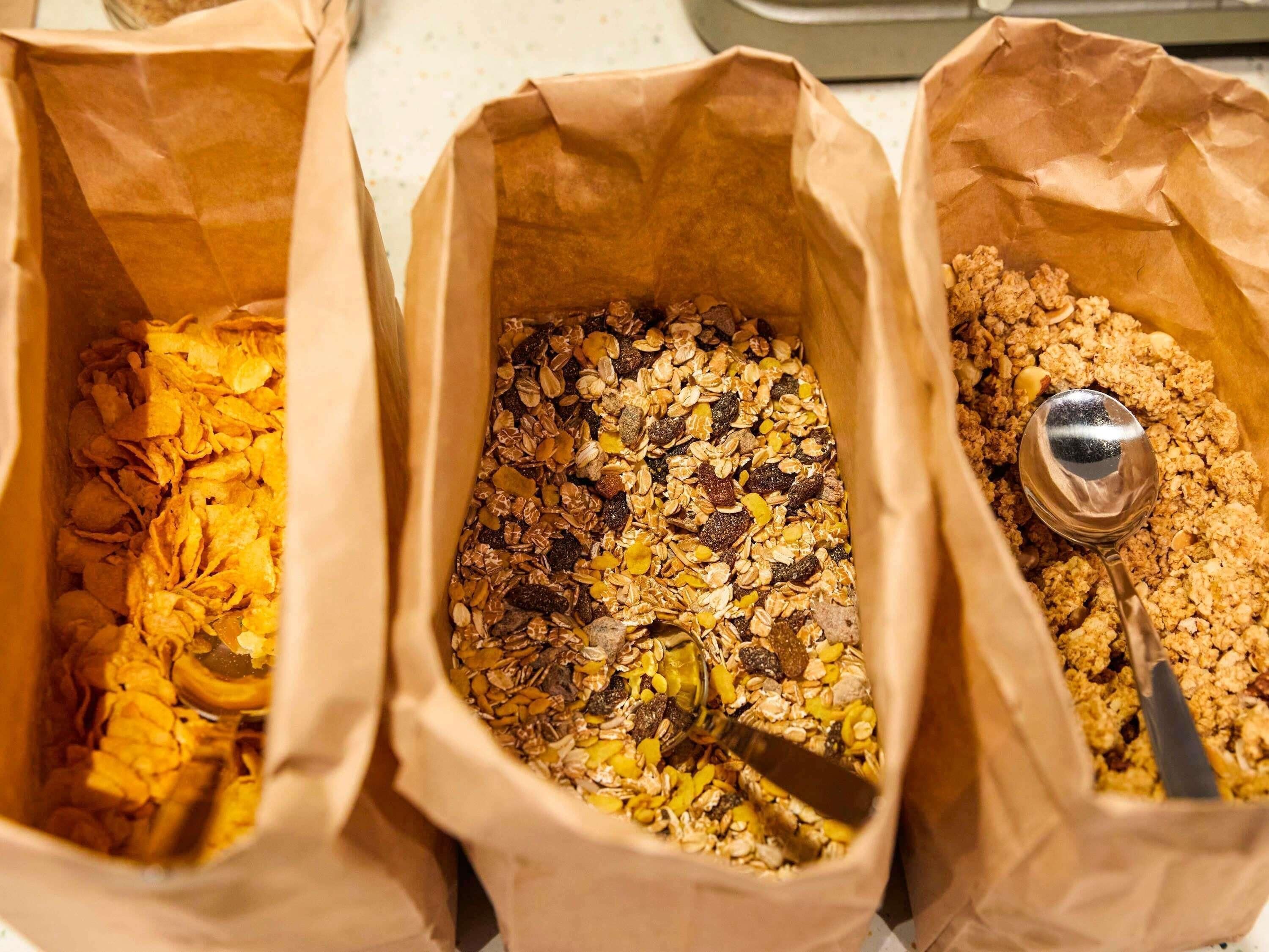 Três sacos de papel cheios de diferentes tipos de granola.