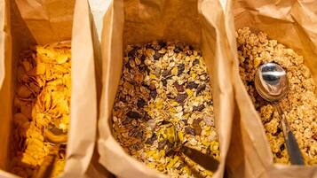 Trois sacs en papier remplis de différents types de granola.