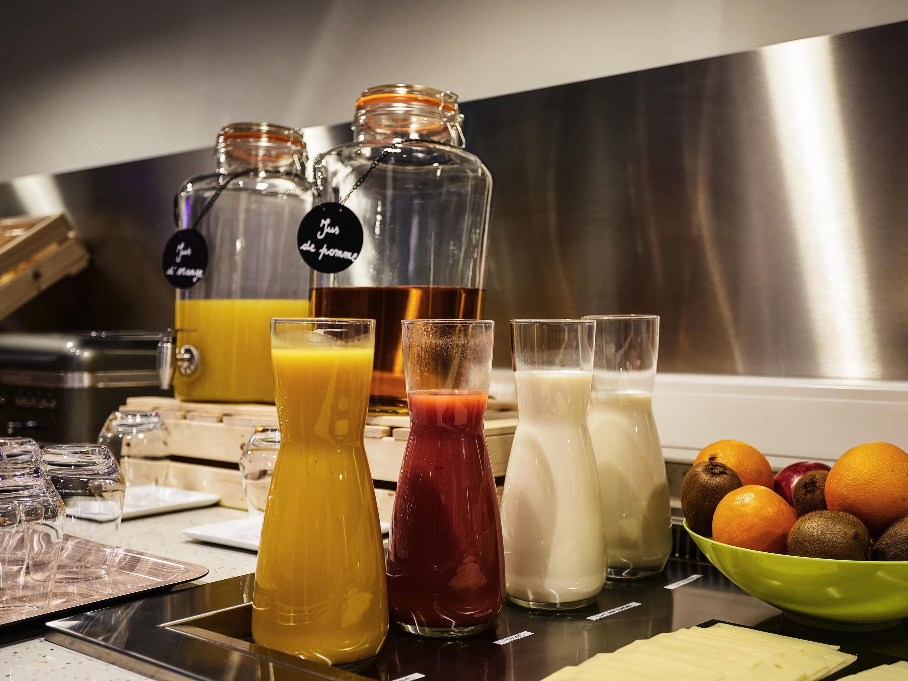 Un espace dédié aux boissons, avec un assortiment de breuvages et un saladier rempli de fruits.