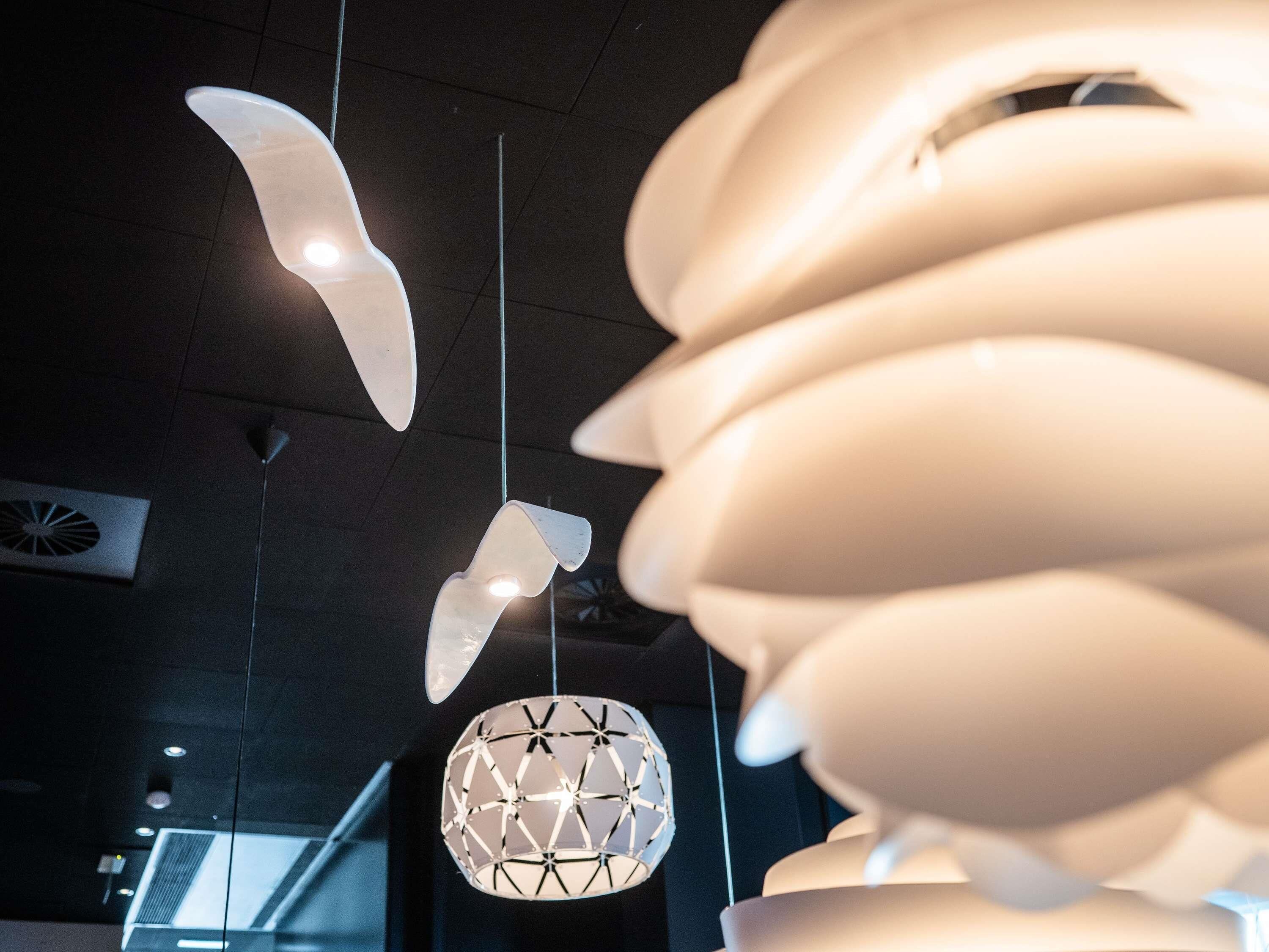 Un interior moderno con lámparas esféricas únicas y una lámpara de techo con diseño geométrico.