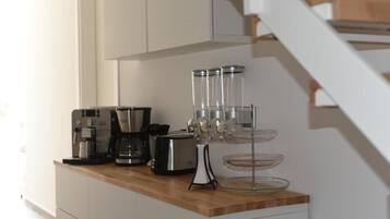 Refrigerador em uma área comum, micro-ondas, fogão, cooktop
