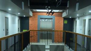 A multi-level interior with a central open space, railings, and a brick wall. - VITS Select Kudro Destinn (Mangaluru)