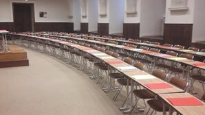 A conference room with long tables and chairs, high ceilings, and arched architectural details. - Hostellerie Charles de Foucauld (Viviers)