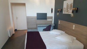 A modern hotel room with a large bed, a desk, and a chair. - Hostellerie Charles de Foucauld (Viviers)