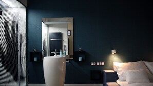 A modern bedroom with a large mirror, a bedside table, and a bed. - Paulay Central Top Studio (Budapest)