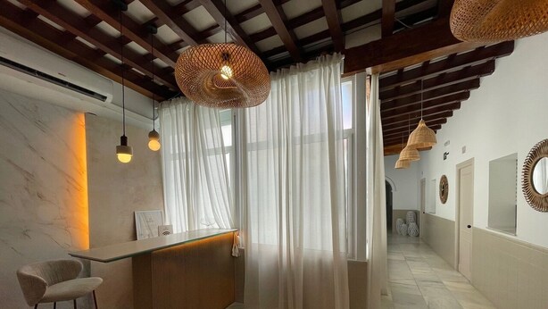 A modern hotel lobby with a reception desk, a bar area, and a seating space. - Bohemia Sanlucar (Sanlucar de Barrameda)