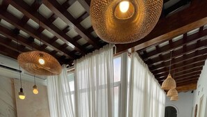 A modern interior with a reception desk, white curtains, hanging wicker lamps, and a marble floor. - Bohemia Sanlucar (Sanlucar de Barrameda)