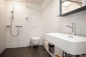 A modern bathroom with a shower, toilet, and sink. - Jugendherberge Schloss Burgdorf - Hostel (Burgdorf)