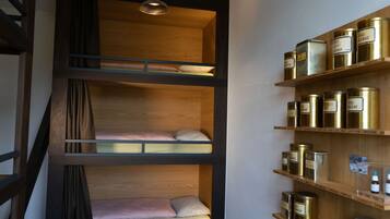 Ein Mehrsteg-Stockbett mit Holz Kopfteilen und einer Ablage mit Metallbehältern.