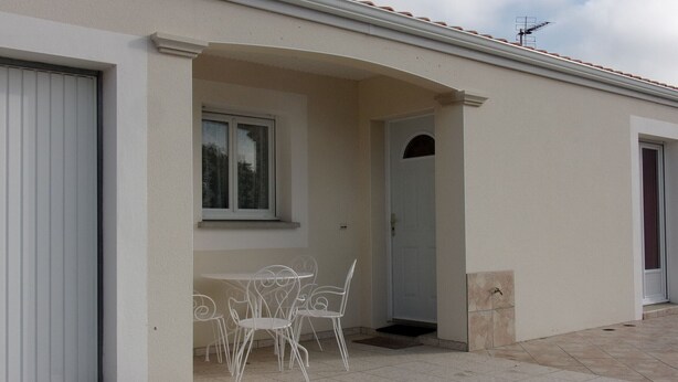 A building with a covered patio area, a door, and a window. - Charming F3 house in Saujon, 2 bedrooms, pets allowed, parking (Saujon)
