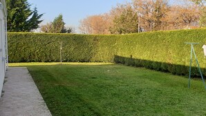 A well-maintained lawn with a hedge and a swing set. - Charming F3 house in Saujon, 2 bedrooms, pets allowed, parking (Saujon)