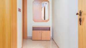 Un pasillo con puertas de madera, un espejo y una tocador con armario.