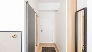 A hallway with a wooden floor, a dark rug, and a white door at the end. - A3 Suite Studio 175Blo-Paris Convention (Paris-15E-Arrondissement)